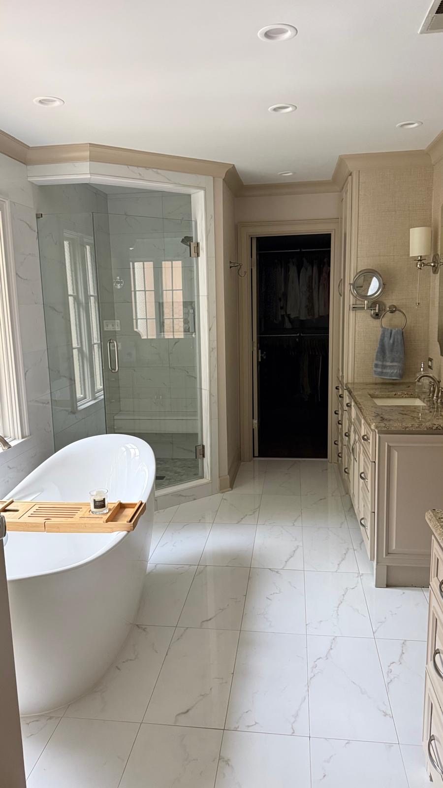 Baño principal con bañera independiente y ducha con puerta de vidrio
